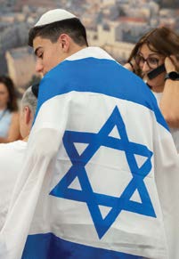 En ung person ifører sig det israelske flag efter at have gjort Aliyah fra Frankrig. (foto: JAFI)